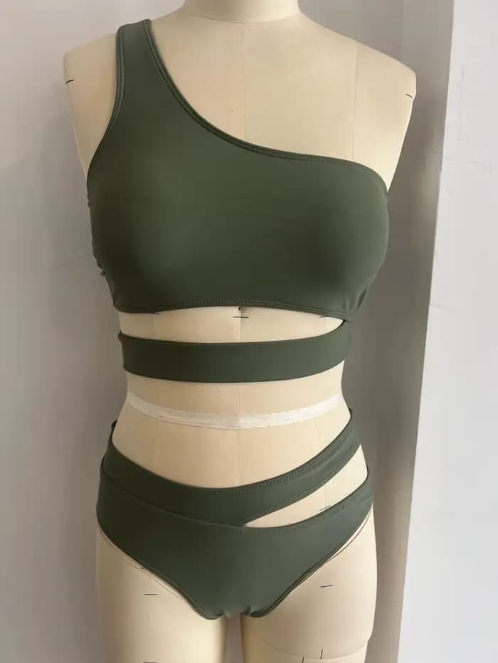 Bikini femme 2026, haut asymétrique vert olive, bas taille haute à découpes latérales, maillot de bain deux pièces uni avec haut court